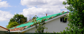 Toit endommagé par le vent sous orage.