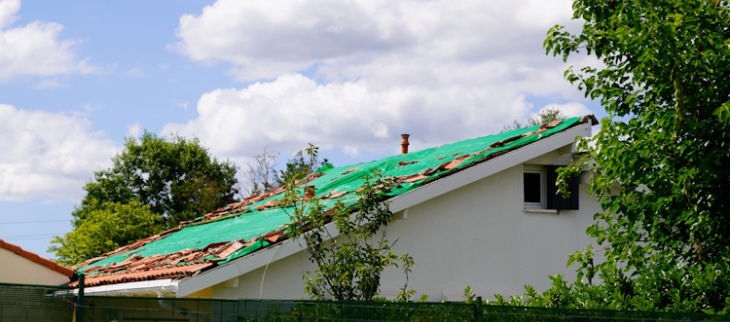 Toit endommagé par le vent sous orage.